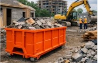 Services 6 Large orange construction dumpster loaded with demolition debris near excavator