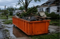 Services 7 Orange roll-off dumpster rental services provided and placed on flooded street after severe storm damage