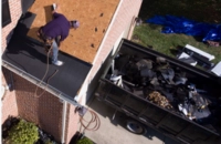 Services 4 Roll-off dump trailer parked in driveway receiving old roof shingles